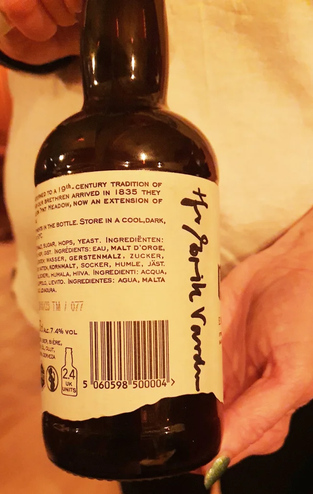 En flaske med signert etikett vises frem