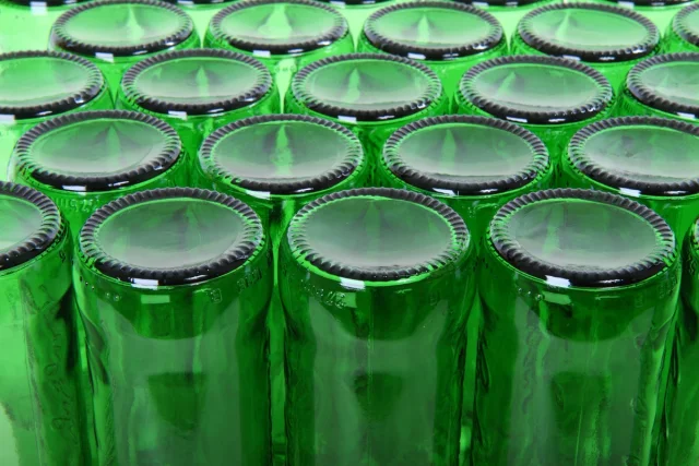 Mange grønne tomflasker tett sammen, opp-ned for tørking