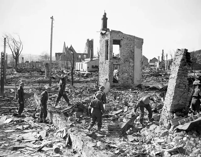 Britiske soldater går igjennom restene av utbrente ruiner etter tysk bombing av Narvik