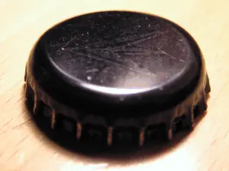 Flaskekapsel som er svart med med annet design under